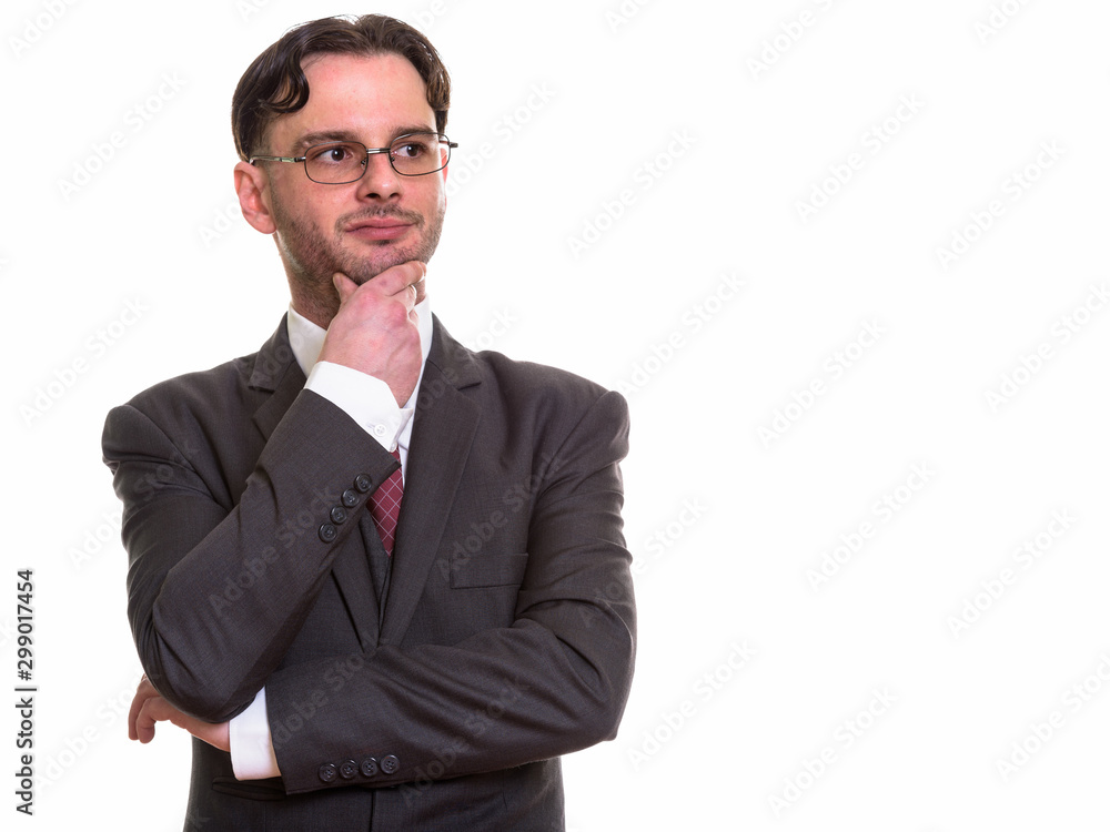 Studio shot of young businessman thinking and looking up Studio shot of young businessman thinking and looking up