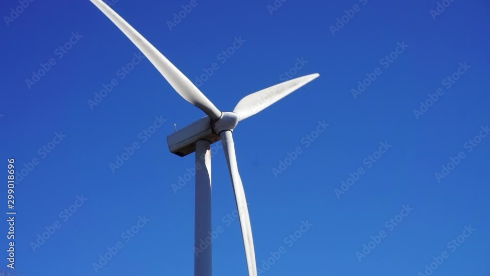 A wind turbine spins on a sunny, clear autumn day. A wind turbine spins on a sunny, clear autumn day.
