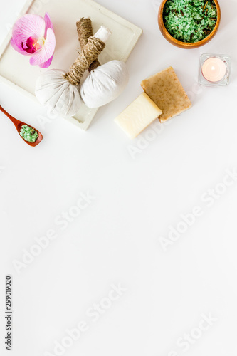 Preparing for massage in spa salon - with candles and orchids - white background top view frame copy space