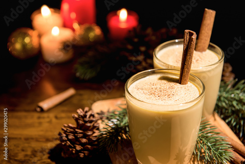 Homemade traditional Christmas eggnog drinks with ground nutmeg, cinnamon and decorating items