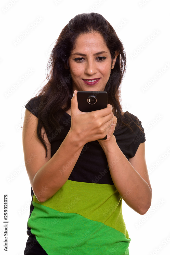 Close up of happy Persian woman smiling while using mobile phone Close up of happy Persian woman smiling while using mobile phone