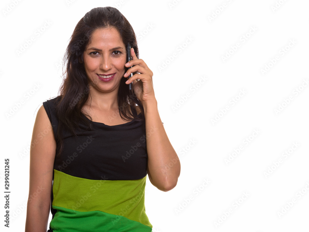 Happy Persian woman smiling while talking on mobile phone Happy Persian woman smiling while talking on mobile phone