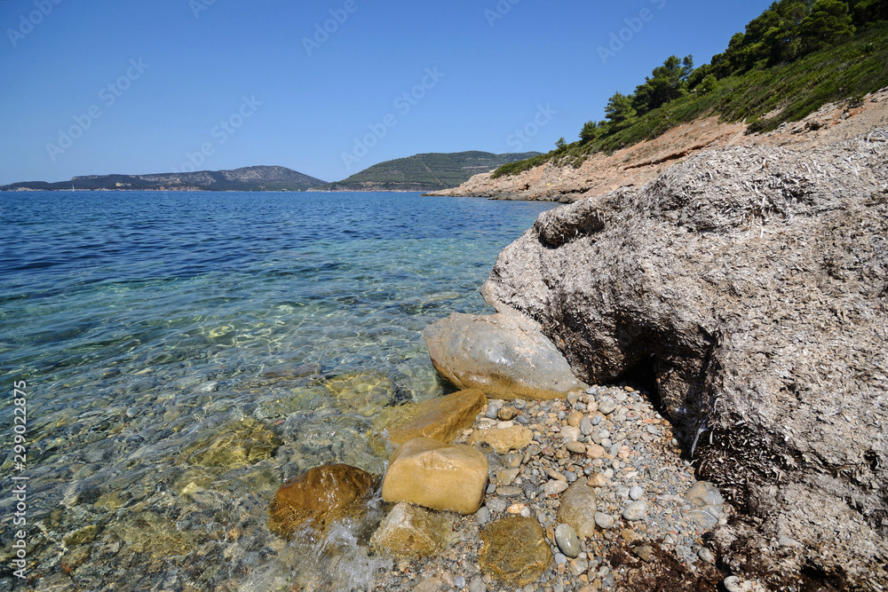 Mediterranean sea and rocks in Punta Giglio promontory of Porto Conte Natural Park near Alghero on a sunny summer day 