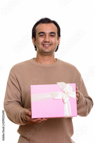 Studio shot of happy Persian man smiling while holding gift box