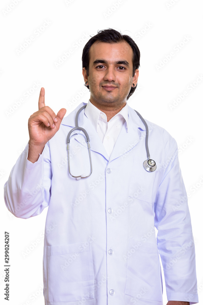 Studio shot of Persian man doctor pointing finger up Studio shot of Persian man doctor pointing finger up