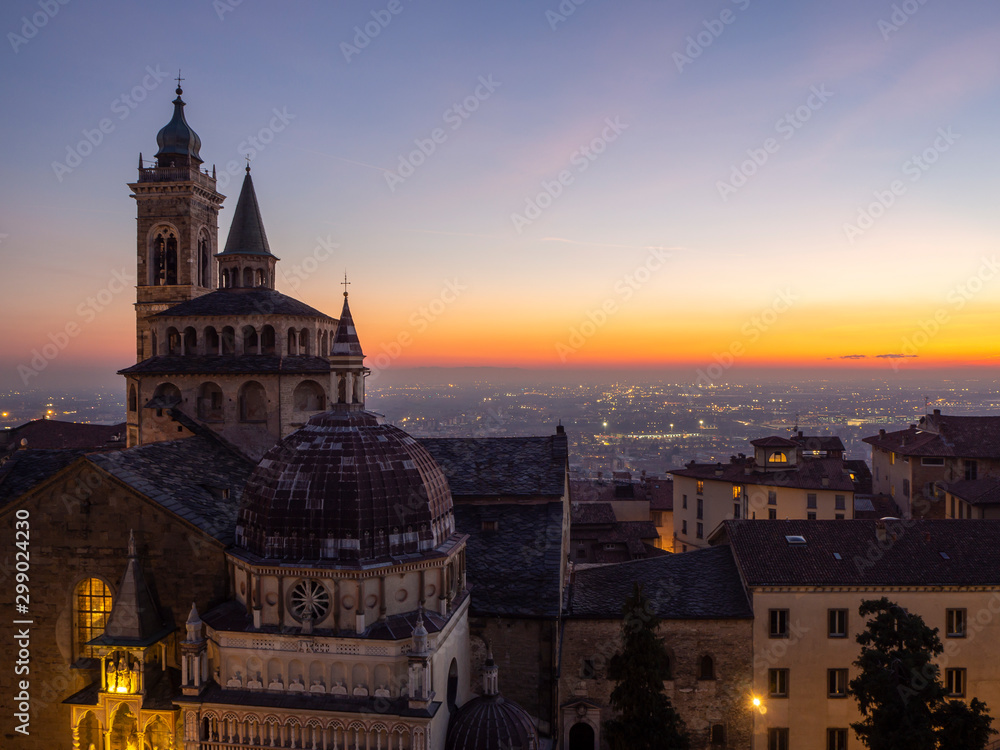Bergamo, Italy. The old town. Amazing aerial view of the Basilica of Santa Maria Maggiore during the sunset. In the background the Po plain. Warm colors