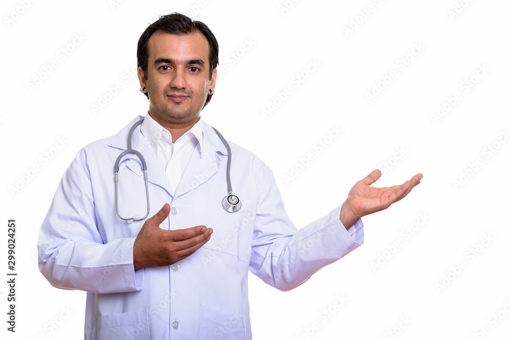Studio shot of Persian man doctor showing something Studio shot of Persian man doctor showing something
