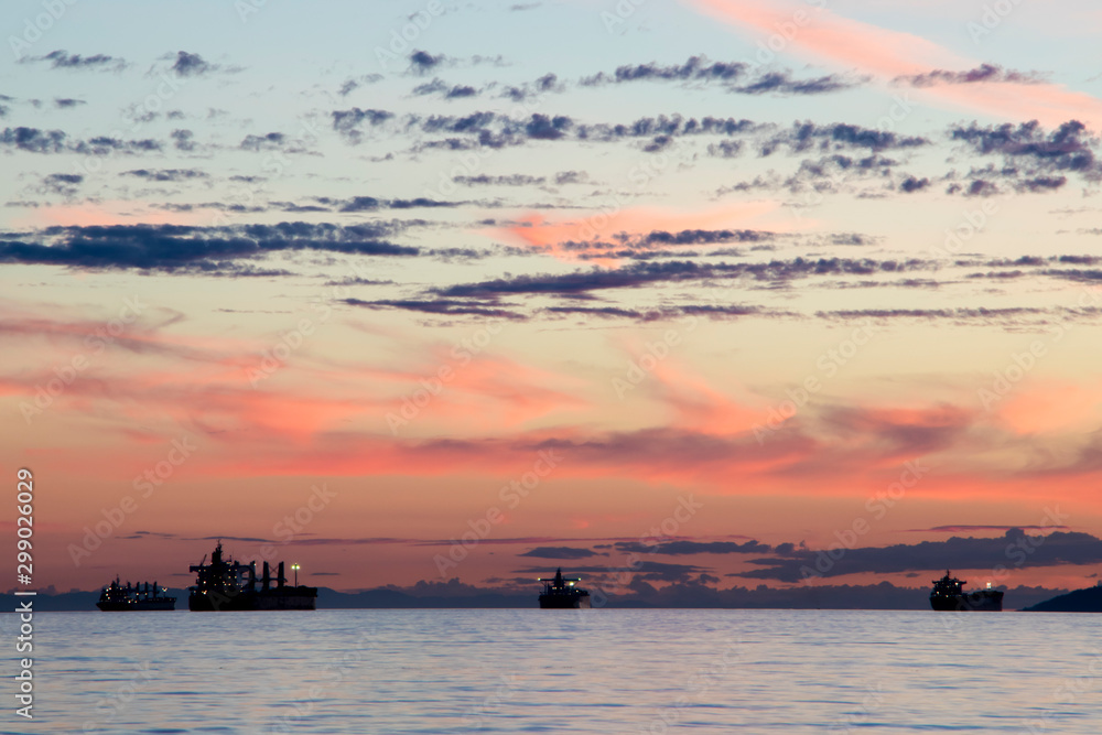 Silhouette of break bulk carrier ship in the sea at sunset.
