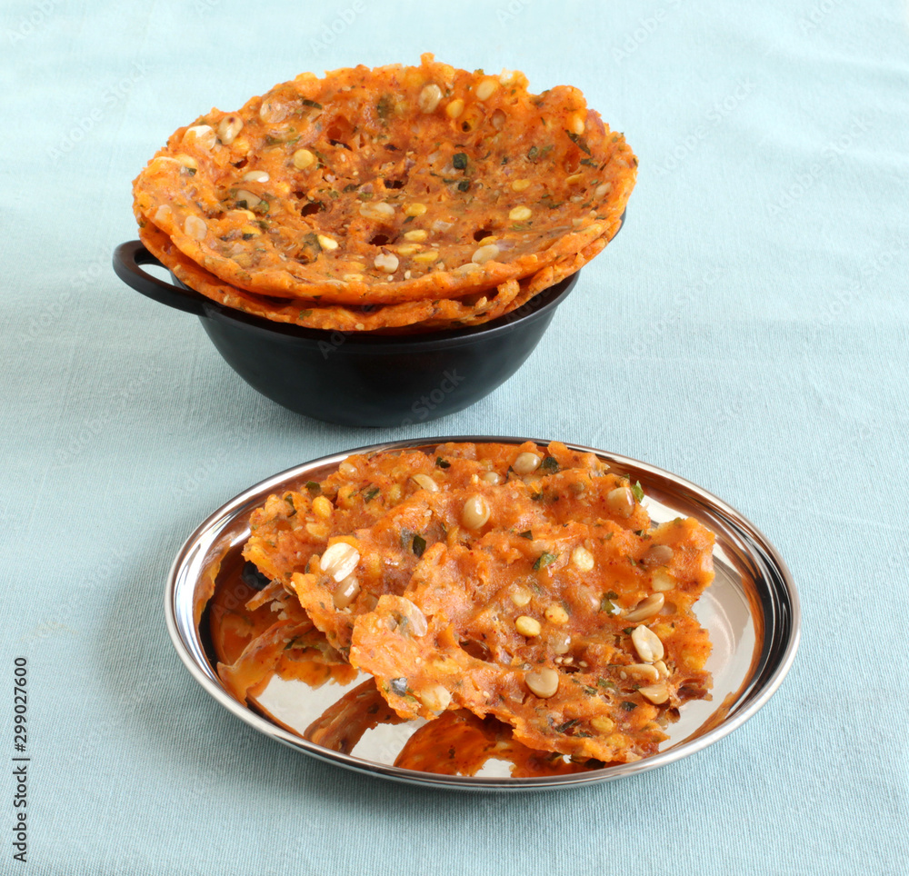 Φωτογραφία Sarva pindi, a dish native to the state of Telangana, India, is a delicious, spicy flat bread, is made from rice flour dough, on a plate and serving wok