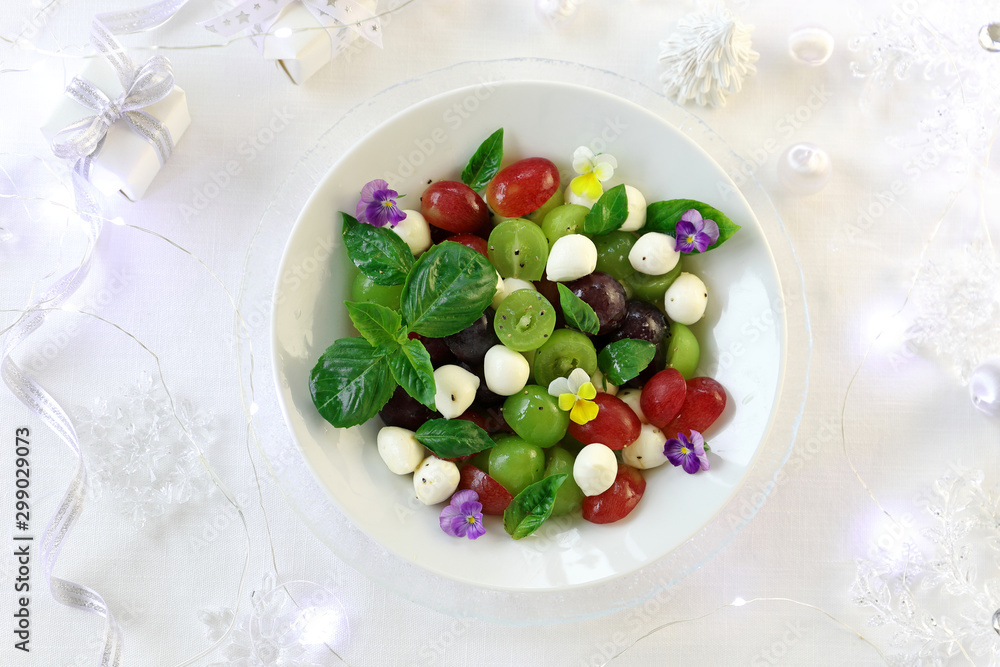 Grape caprese salad on white christmas background Grape caprese salad on white christmas background