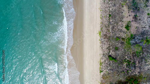Beach on aerial drone top view with ocean waves reaching shore. photo