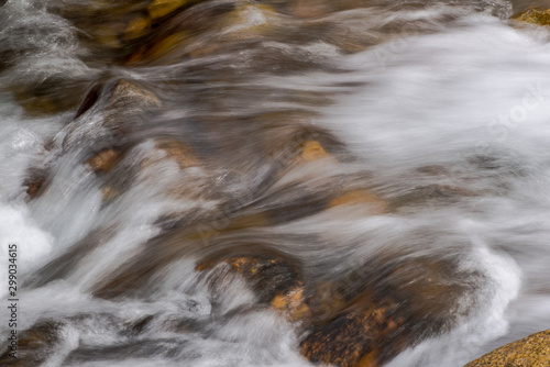 the flow of a mountain river with rounded stones