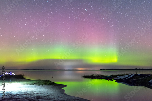 Wallpaper Mural picture with a northern lights on the lake, blurred background.  fuzzy and moving human silhouettes in the foreground Torontodigital.ca