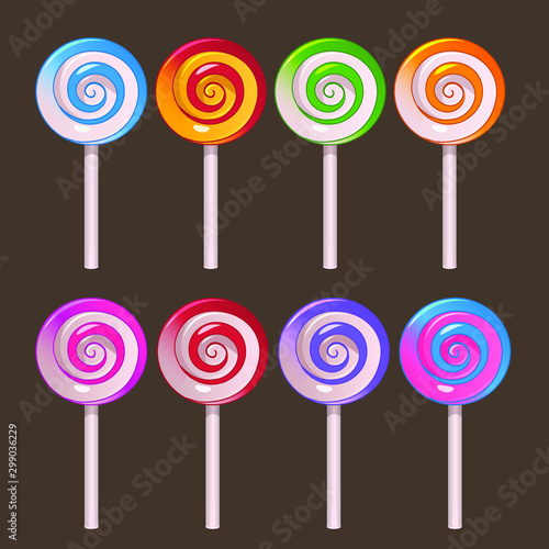 Colored lollipops on stick set on dark background