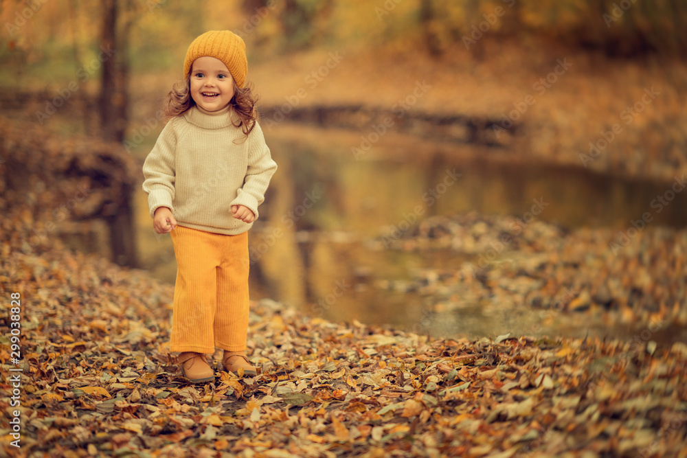 happy girl in beanie walking in the autumn park at daytime happy girl in beanie walking in the autumn park at daytime
