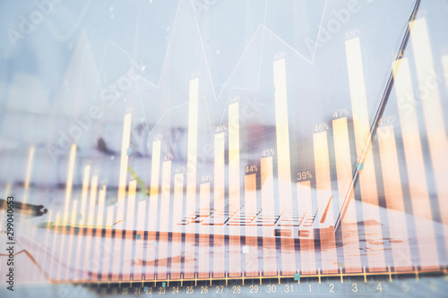 Forex graph hologram on table with computer background. Multi exposure. Concept of financial markets.