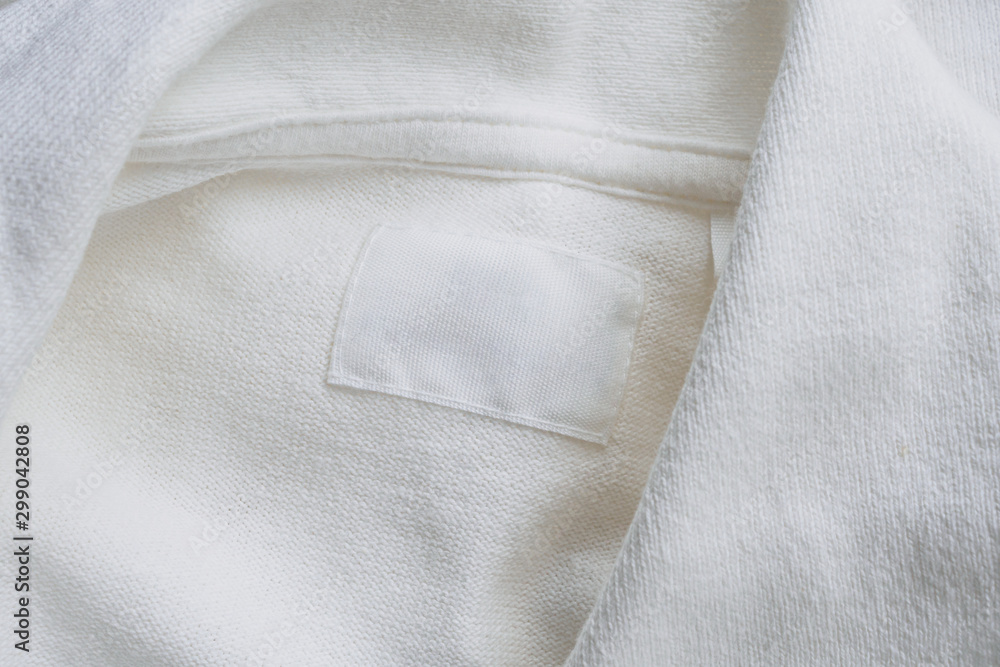 Fototapeta premium Blank white clothes label on new cotton shirt background