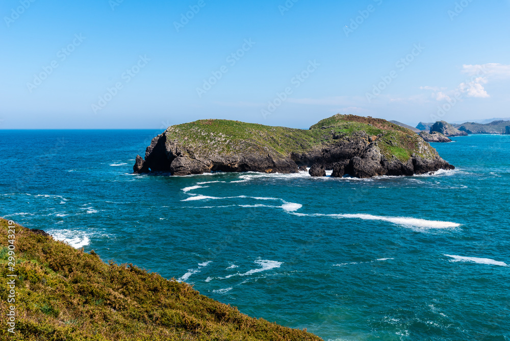 Scenic view of sea against blue sky in rocky coast