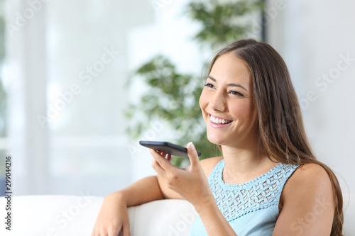 Happy woman uses voice recognition on mobile phone