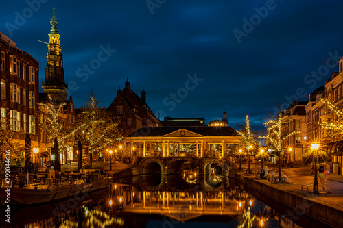 The illuminated Koornbrug, the trees with christmas ornaments and the spire of the town hall in the background during the blue hour, Leiden, the Netherlands photo