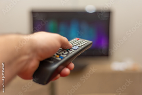 A person with a TV remote controls the remote control to switch channels to watch TV shows.