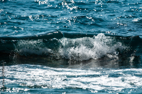 sea wave splashes over stone