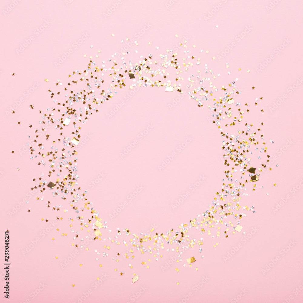 Round copy space of gold confetti on pink background