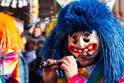Marktplatz, Basel, Switzerland - March 13th, 2019. Close-up of a carnival participant in a colorful costume playing piccolo flute