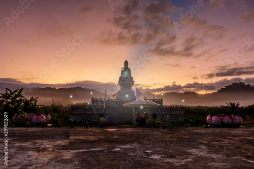 Sunrise of Goddess statue behind mountain range with beautiful orange sky