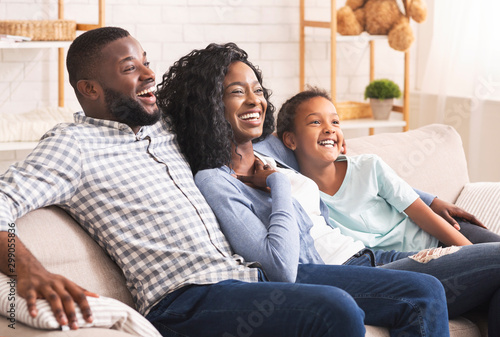 Εκτύπωση καμβά Joyful african american family watching comedy show on tv together