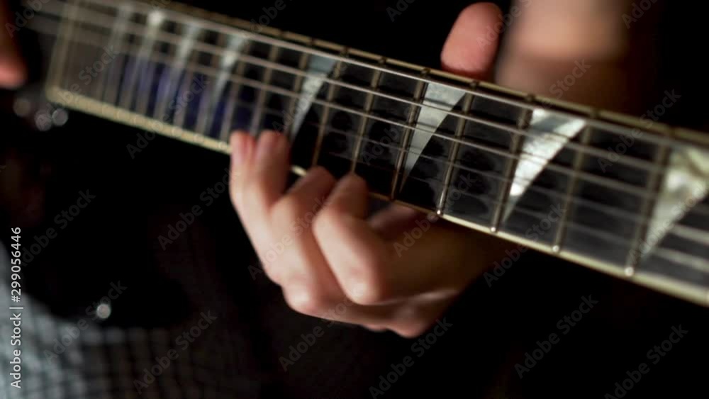 Close-up of the hand of a musician playing an electric guitar, a guitarist from the band makes a recording in the Studio, slow motion, camera slide Close-up of the hand of a musician playing an electric guitar, a guitarist from the band makes a recording in the Studio, slow motion, camera slide