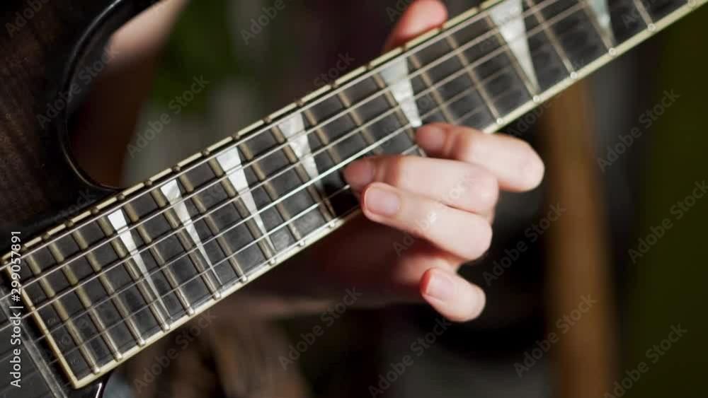 A young male lead guitarist plays an electric guitar. Slow motion. Close-up of hands and guitar. A young male lead guitarist plays an electric guitar. Slow motion. Close-up of hands and guitar.