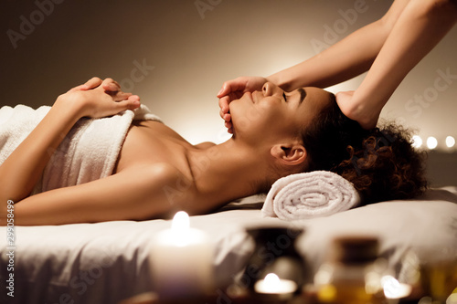 Spa treatment. Afro woman enjoying face massage