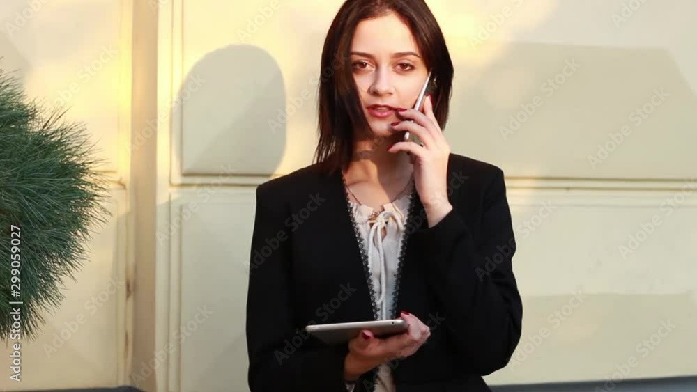 Black haired girl.Business woman in black classic suit.White blouse.Fashion style.Working with phone and tablet. Black haired girl.Business woman in black classic suit.White blouse.Fashion style.Working with phone and tablet.