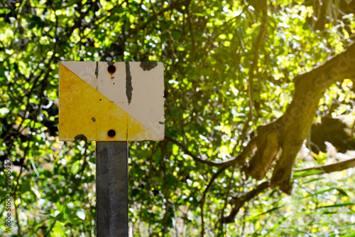 Yellow and white metal sign of mountain and trails