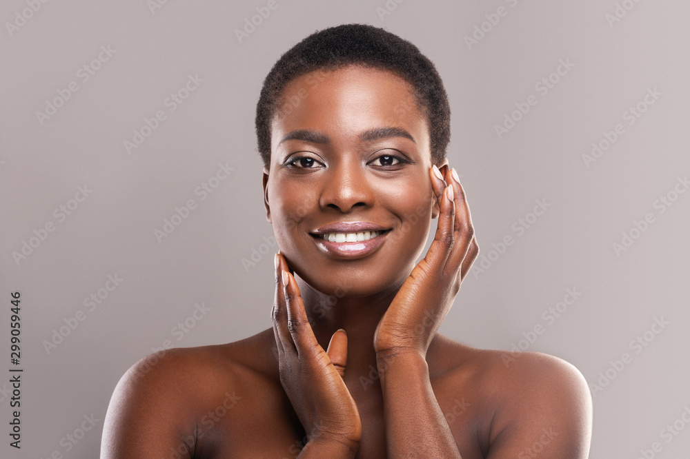 Foto de Beautiful black woman with short hair touching her smooth ...