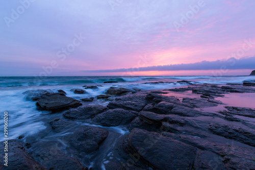 Scenic view of rock formation on the coastline with sunrise sky.