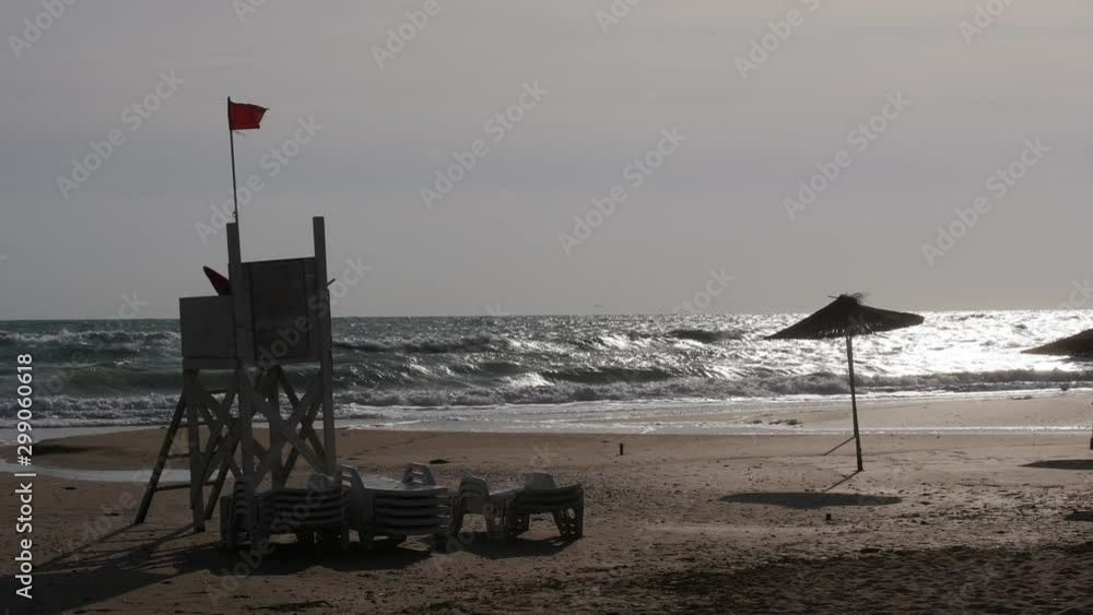 Stormy sea. Red flag on the beach. Swimming is prohibited. Stormy sea. Red flag on the beach. Swimming is prohibited.
