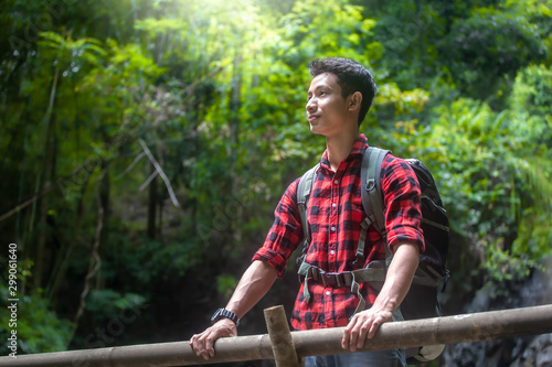 Young Hiker man standing in bamboo forest with backpack. travel concept.