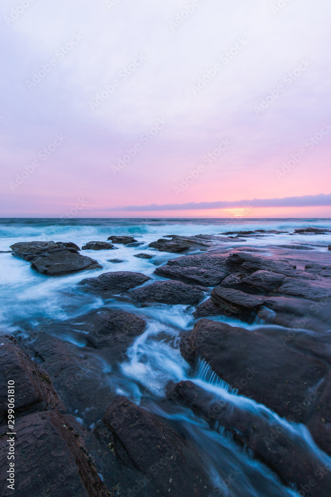 Water flowing through the rocks in an overcast sunrise.