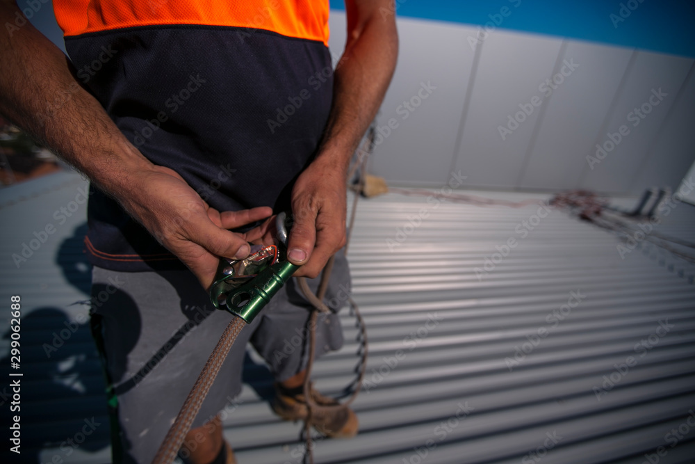 Rope access industry worker inspecting clipping rope into advantage mechanical pulley system prior used on construction building site in Sydney city CBD, Australia Rope access industry worker inspecting clipping rope into advantage mechanical pulley system prior used on construction building site in Sydney city CBD, Australia