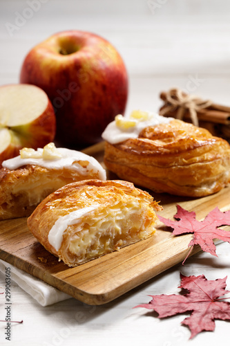 piece of cinnamon apple pie on a wooden board with fresh apple in background, autumn food concept