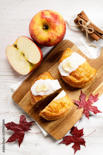 piece of cinnamon apple pie on a wooden board with fresh apple in background, autumn food concept