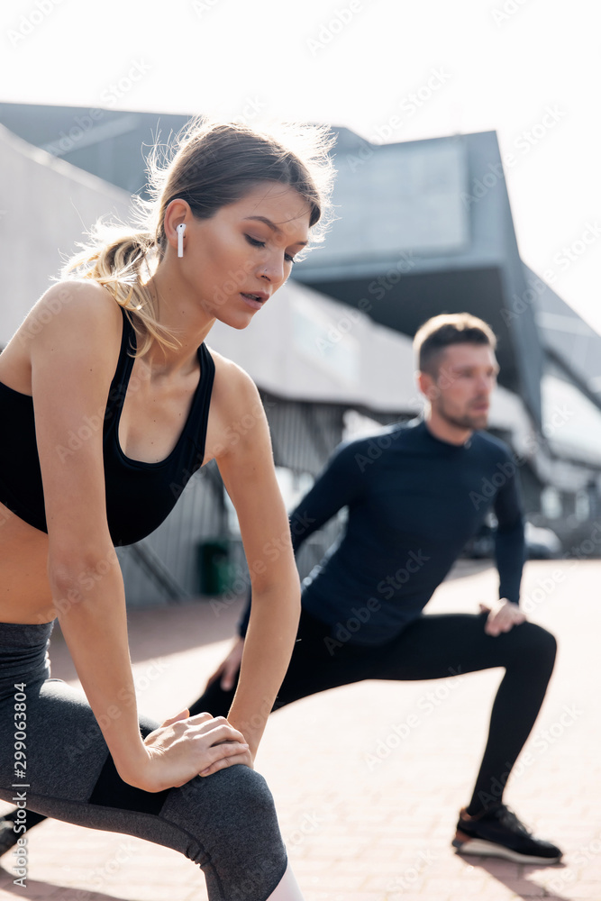fitness, sport, training and lifestyle concept - man and woman stretching outdoors fitness, sport, training and lifestyle concept - man and woman stretching outdoors