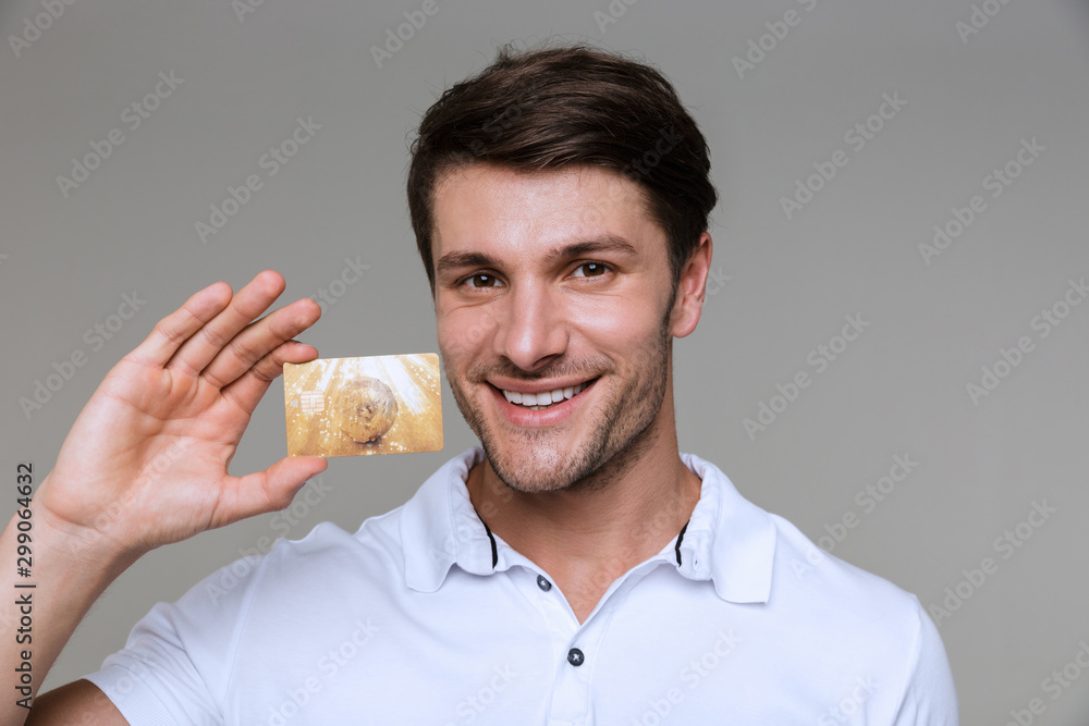Smiling pleased man holding debit card. Smiling pleased man holding debit card.