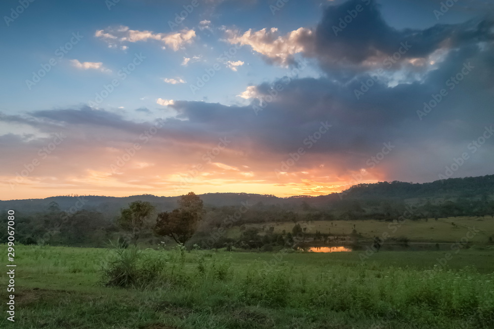 Mountain view evening of green grass field around with the hill with red sun light and cloudy sky background, sunset at Thung Salang Luang, Khao Kho, Phetchabun, Thailand. Mountain view evening of green grass field around with the hill with red sun light and cloudy sky background, sunset at Thung Salang Luang, Khao Kho, Phetchabun, Thailand.