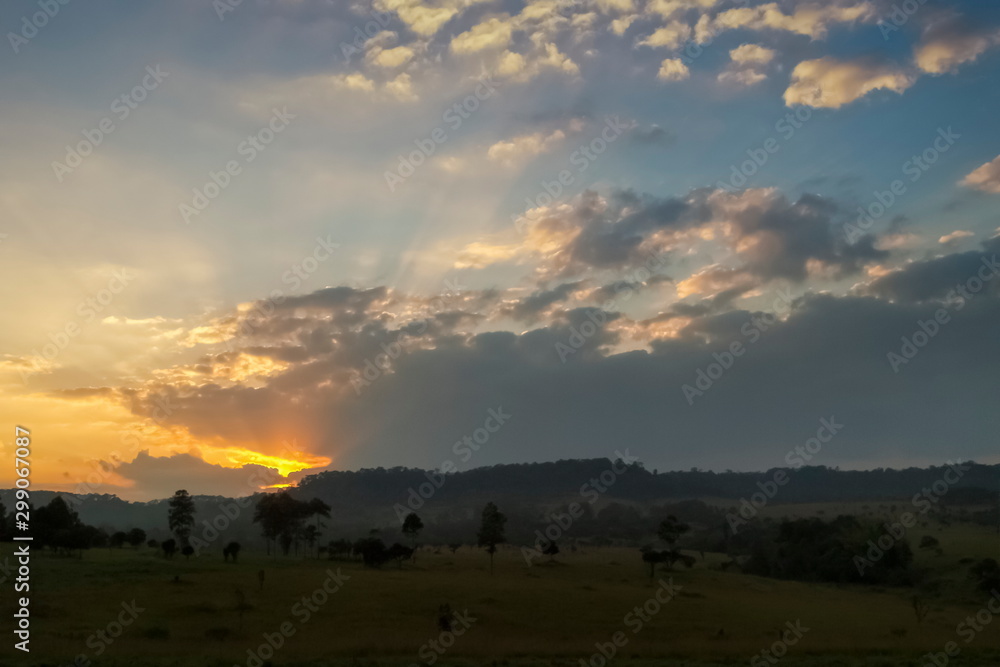 Mountain view evening of green grass field around with the hill with red sun light and cloudy sky background, sunset at Thung Salang Luang, Khao Kho, Phetchabun, Thailand.