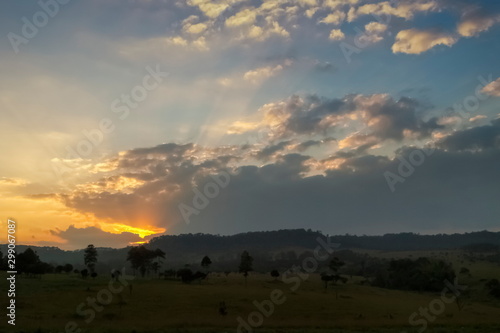 Mountain view evening of green grass field around with the hill with red sun light and cloudy sky background  sunset at Thung Salang Luang  Khao Kho  Phetchabun  Thailand.