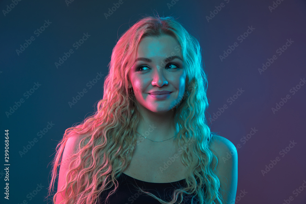 Caucasian young woman's portrait on gradient background in neon light. Beautiful female model with unusual look. Concept of human emotions, facial expression, sales, ad. Smiling cute. Caucasian young woman's portrait on gradient background in neon light. Beautiful female model with unusual look. Concept of human emotions, facial expression, sales, ad. Smiling cute.