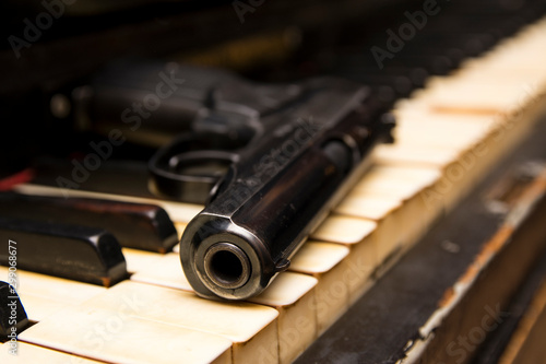 Dlack gun on the keys of piano close up photo